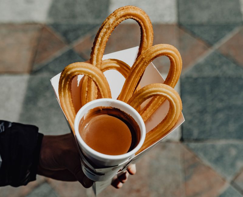 Imagen de unos churros con chocolate que han sido recogidos para llevar.